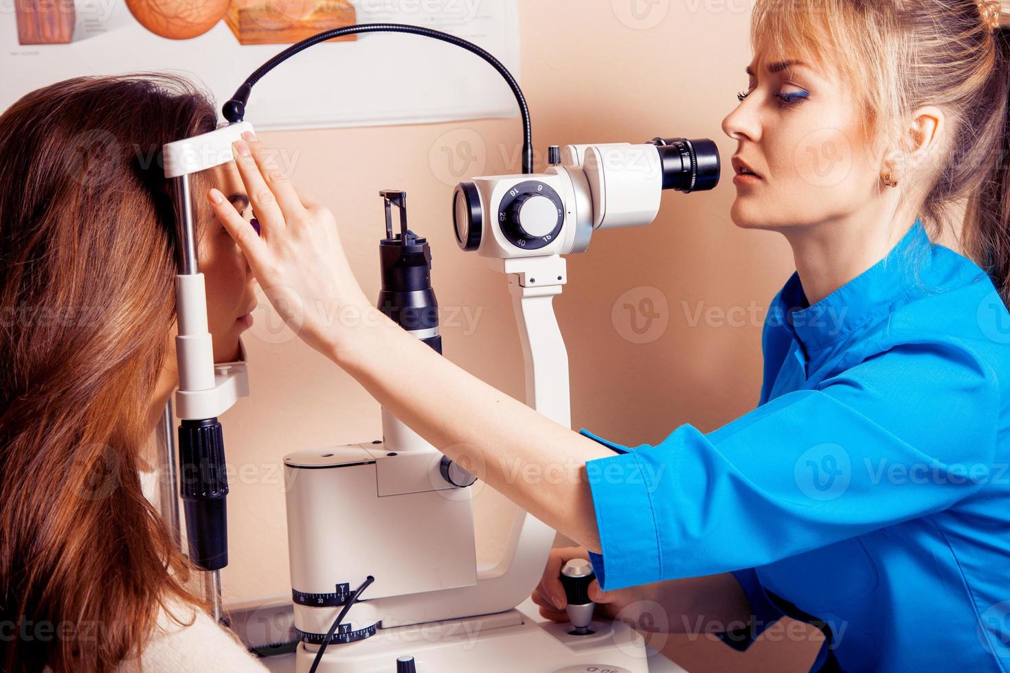 allvarlig kvinna läkare checkar henne syn till de patient i de klinik foto