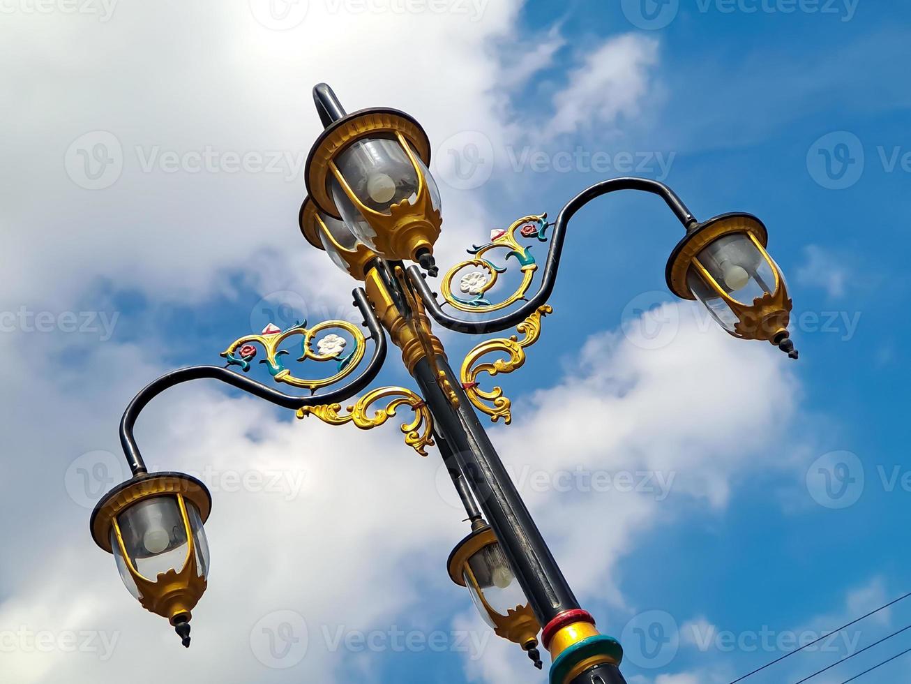 klassisk modell stad lampor med svart guld järn sniderier, skön ljus blå himmel skott på låg vinkel. foto