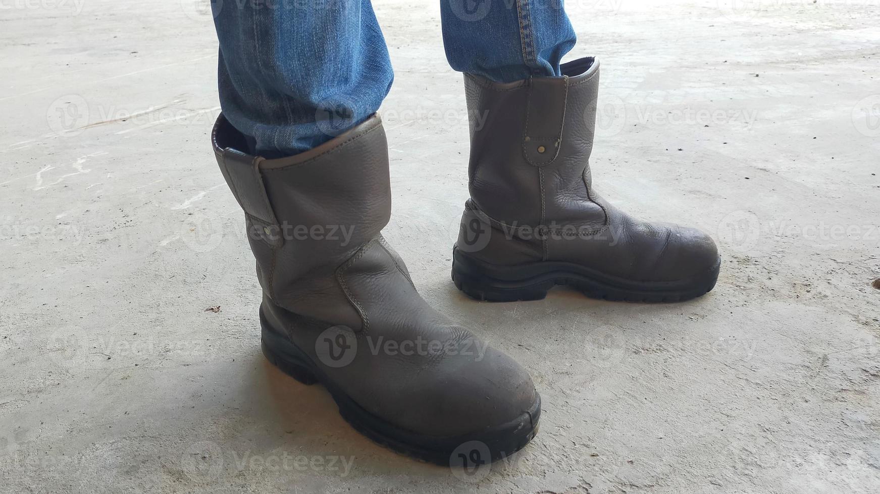 en par av brun man säkerhet skor och jeans. foto