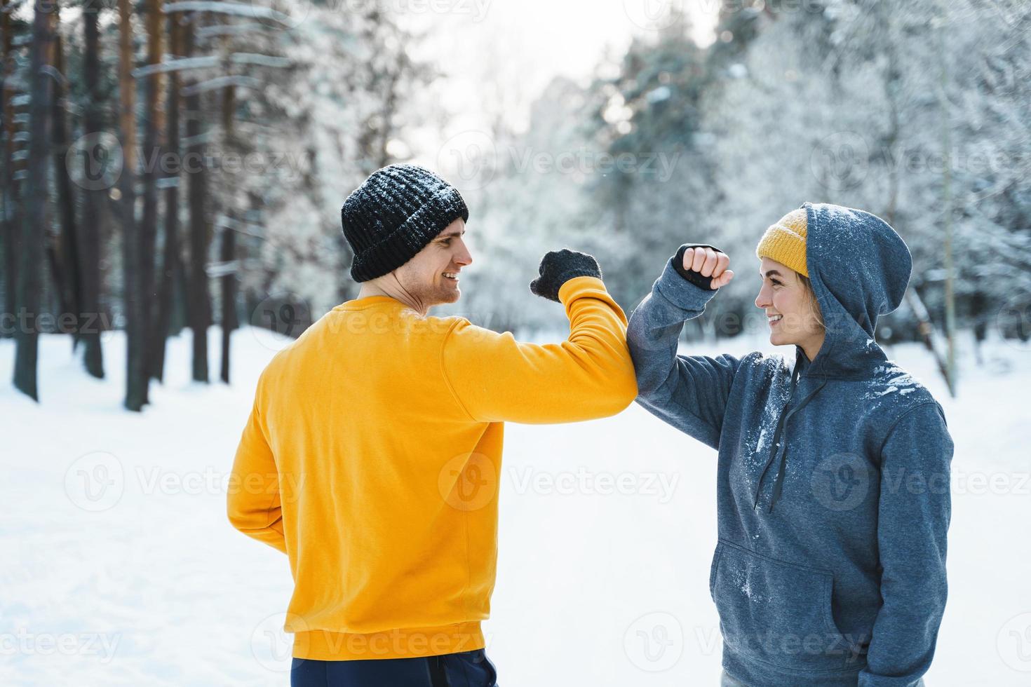 två joggare hälsning varje Övrig med en armbåge stöta gest under vinter- träna foto