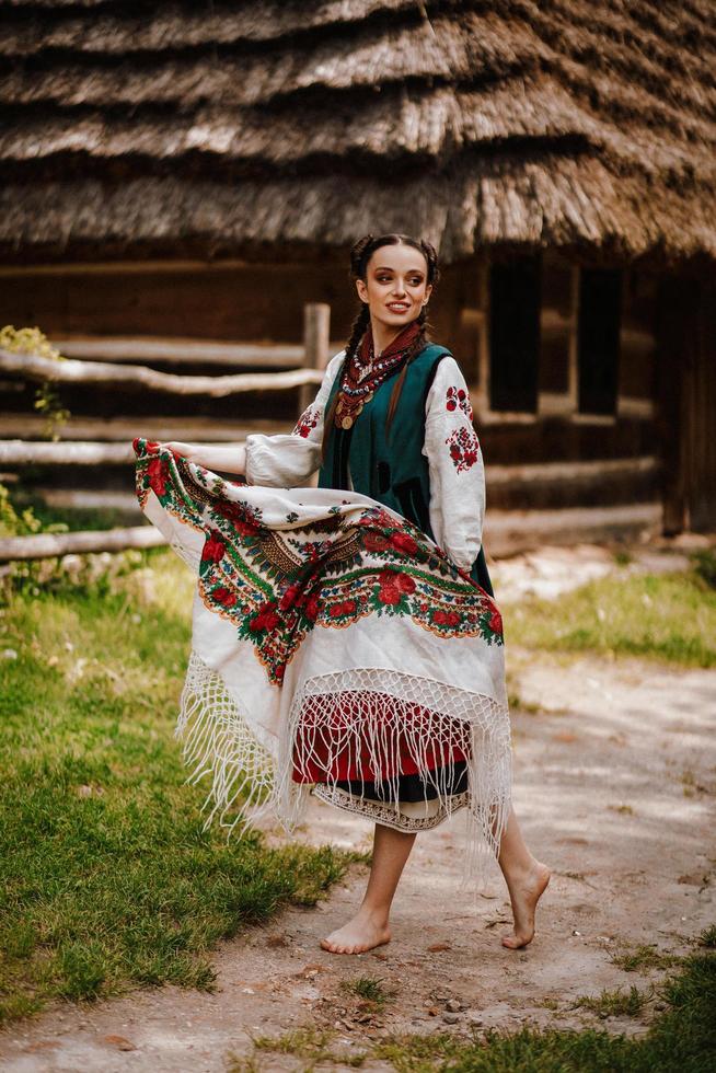 ung flicka i en färgglad traditionell ukrainsk klänning dansar foto