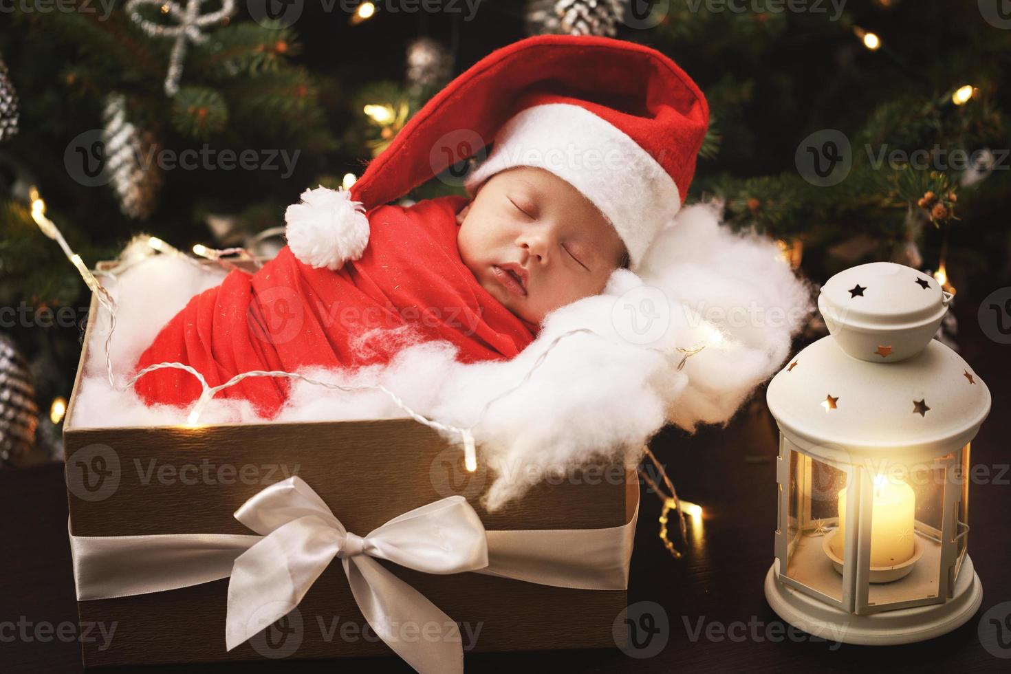 söt nyfödd bebis bär santa claus hatt är sovande i de jul gåva låda foto