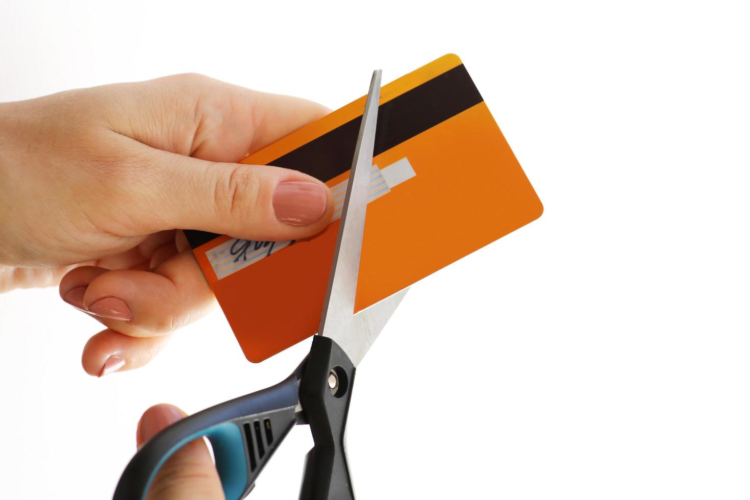 kvinna skärande henne kreditera kort med en sax foto