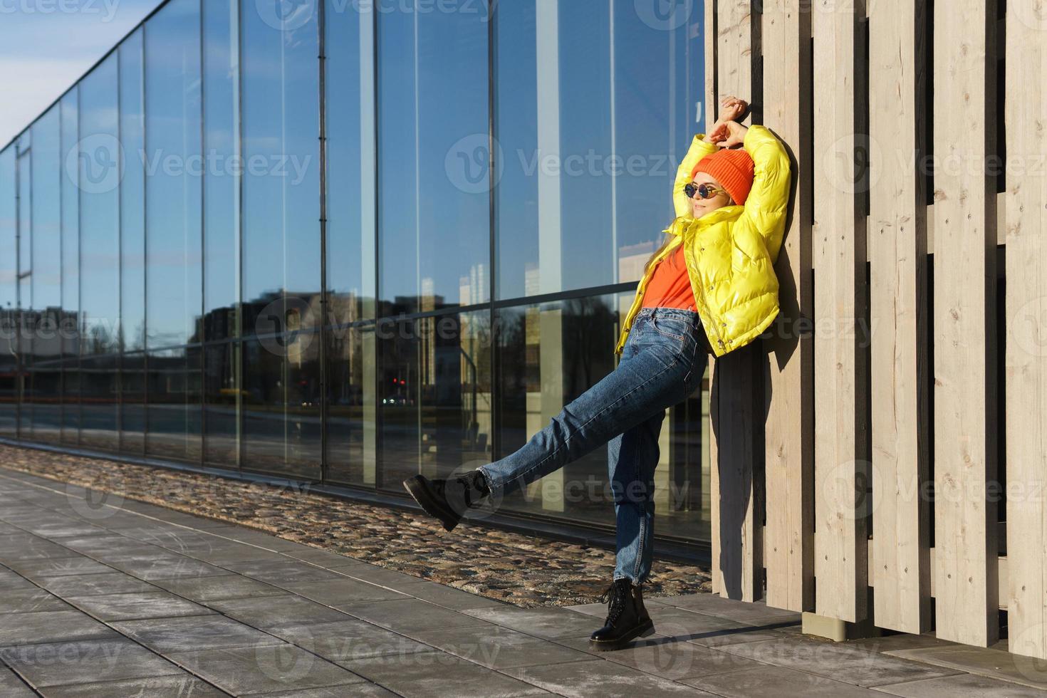 eleganta flicka bär gul puffer och orange stickat hatt foto