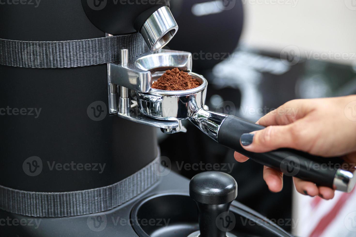 Barista slipa kaffe bönor in i de portafilter foto