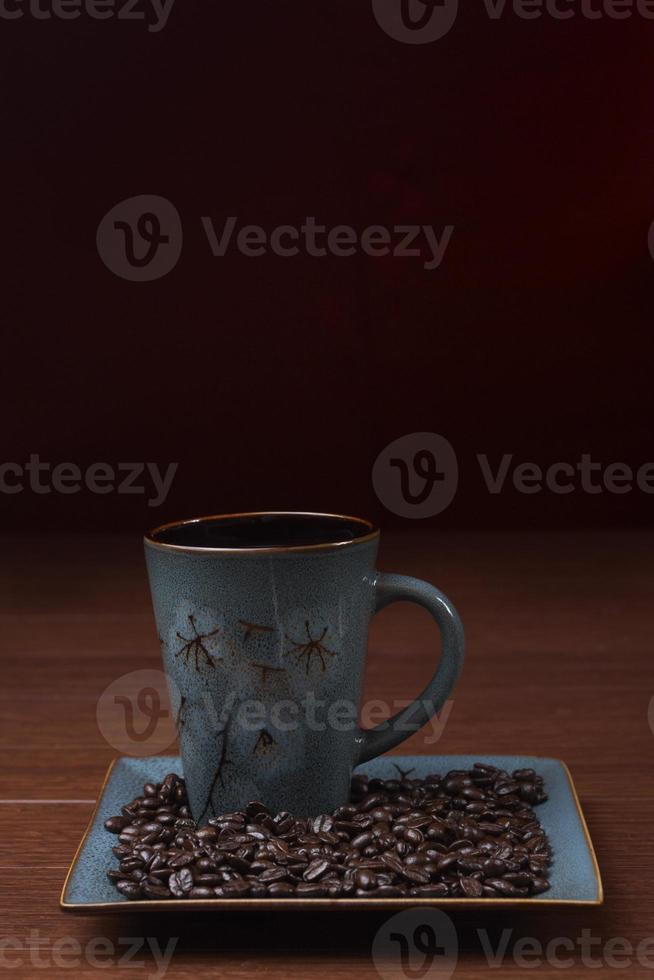 en kopp kaffe med kaffebönor foto