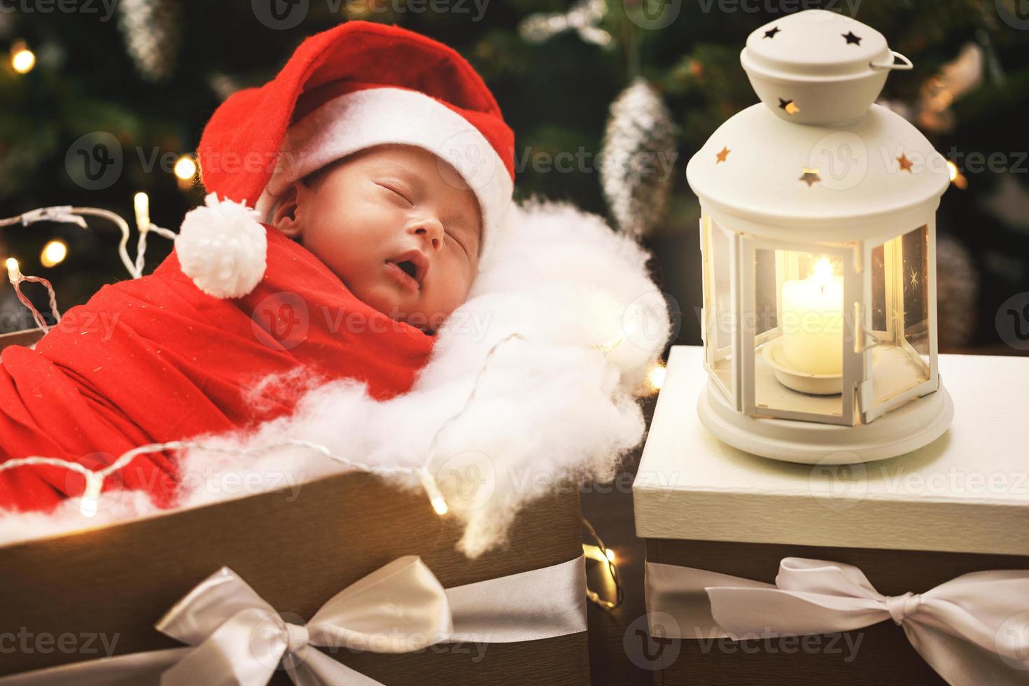 söt nyfödd bebis bär santa claus hatt är sovande i de jul gåva låda foto