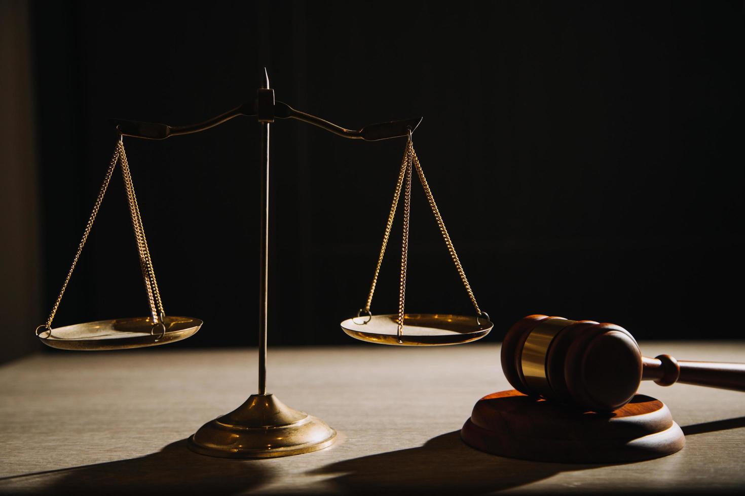 rättvisa och lag koncept.manlig domare i en rättssal med klubban, arbetar med, dator och dockningstangentbord, glasögon, på bordet i morgonljus foto