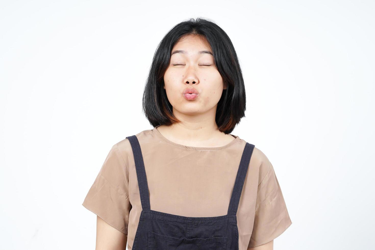 stängd ögon och blåser kyss av skön asiatisk kvinna isolerat på vit bakgrund foto