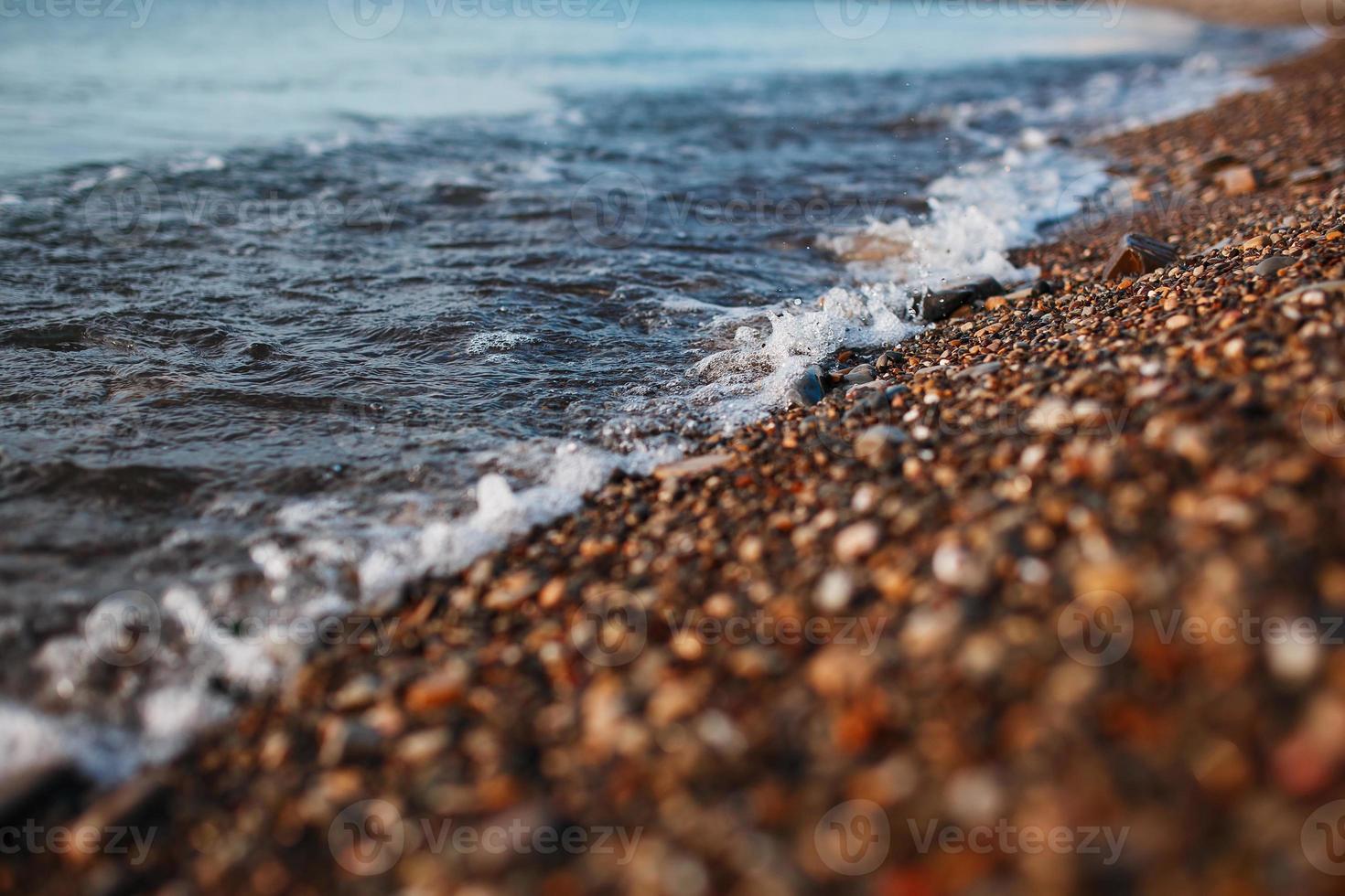 hav vågor av de blå hav med skum rulla i land de gyllene Strand. närbild foto