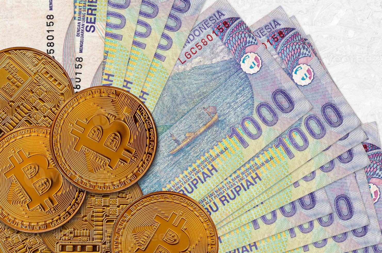 1000 indonesiska rupiah räkningar och gyllene bitcoins. kryptovaluta investering begrepp. crypto brytning eller handel foto
