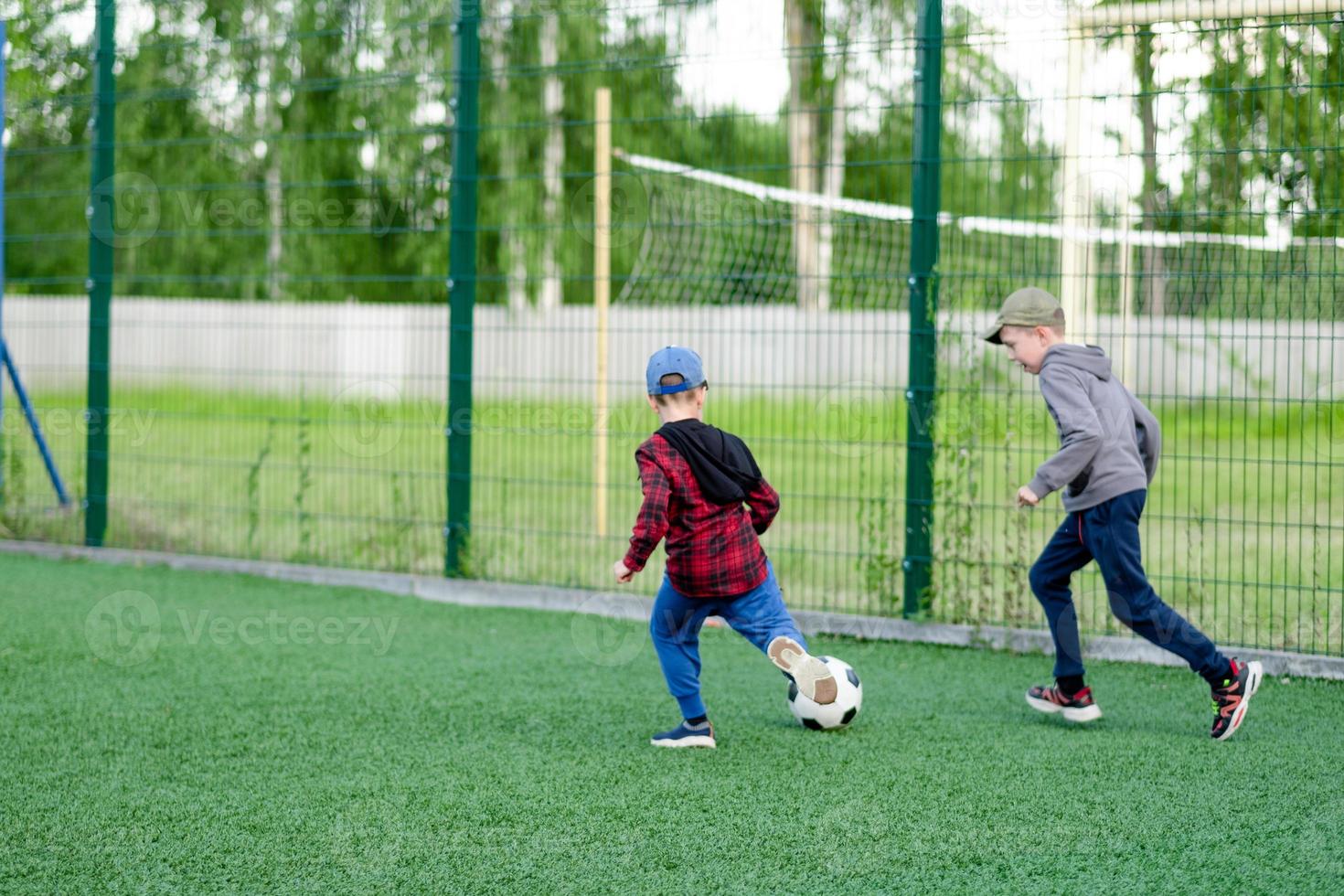 barn spela fotboll i de gård, på de gräsmatta foto