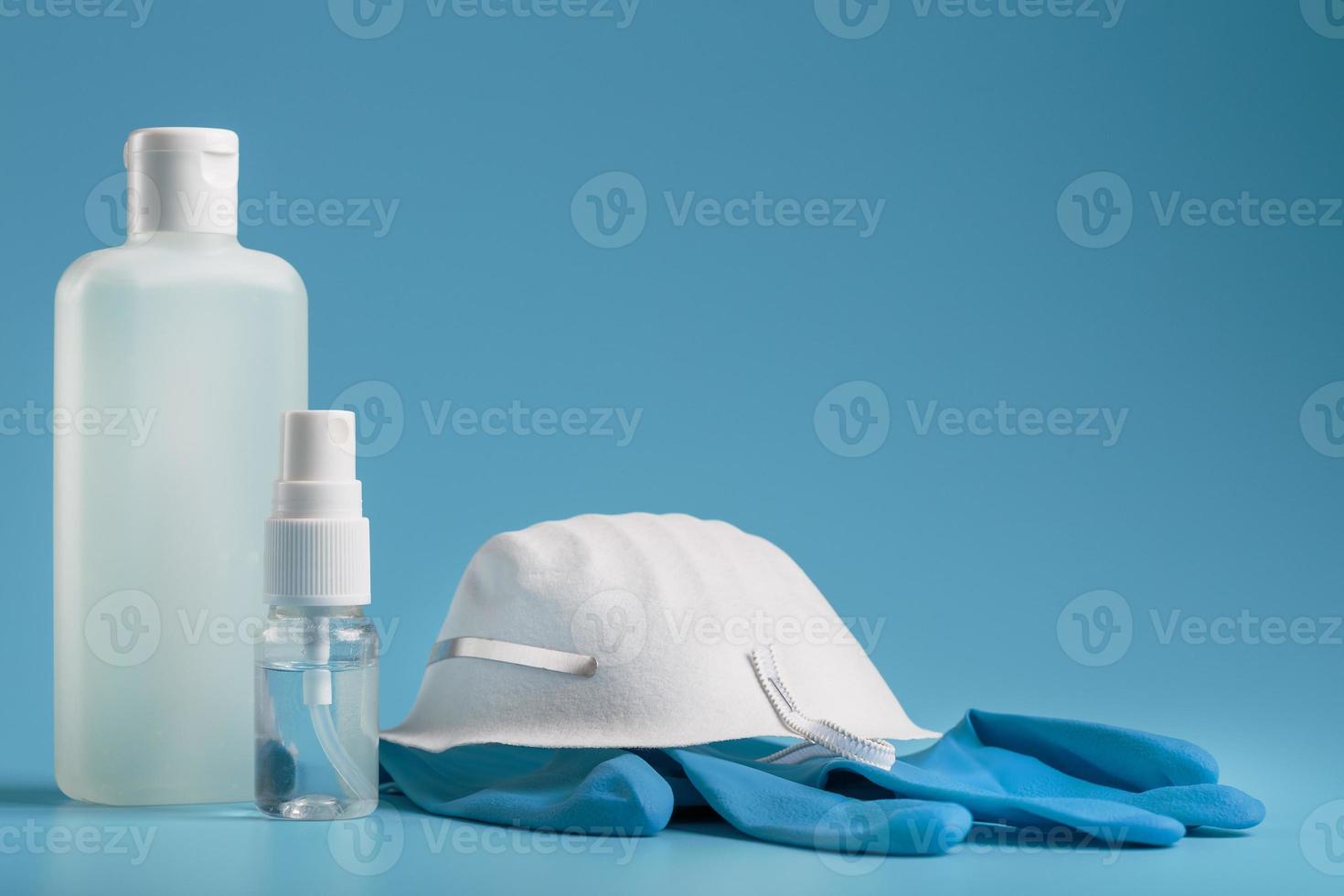 anti-virus skydd utrustning på en blå bakgrund, mask, sudd handskar, hand desinfektionsmedel flaskor, antiseptisk gel. foto