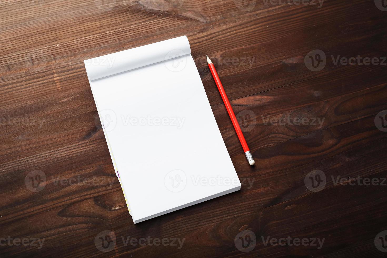 anteckningsblock med röd penna på en brun trä- tabell bakgrund, för utbildning, skriva mål och gärningar foto