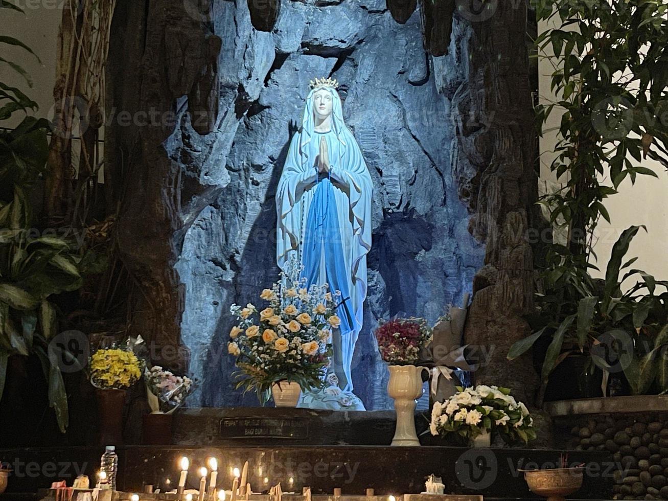 de grotta av jungfrulig Mary, staty av jungfrulig mary i en sten grotta kapell katolik kyrka med tropisk vegetation foto