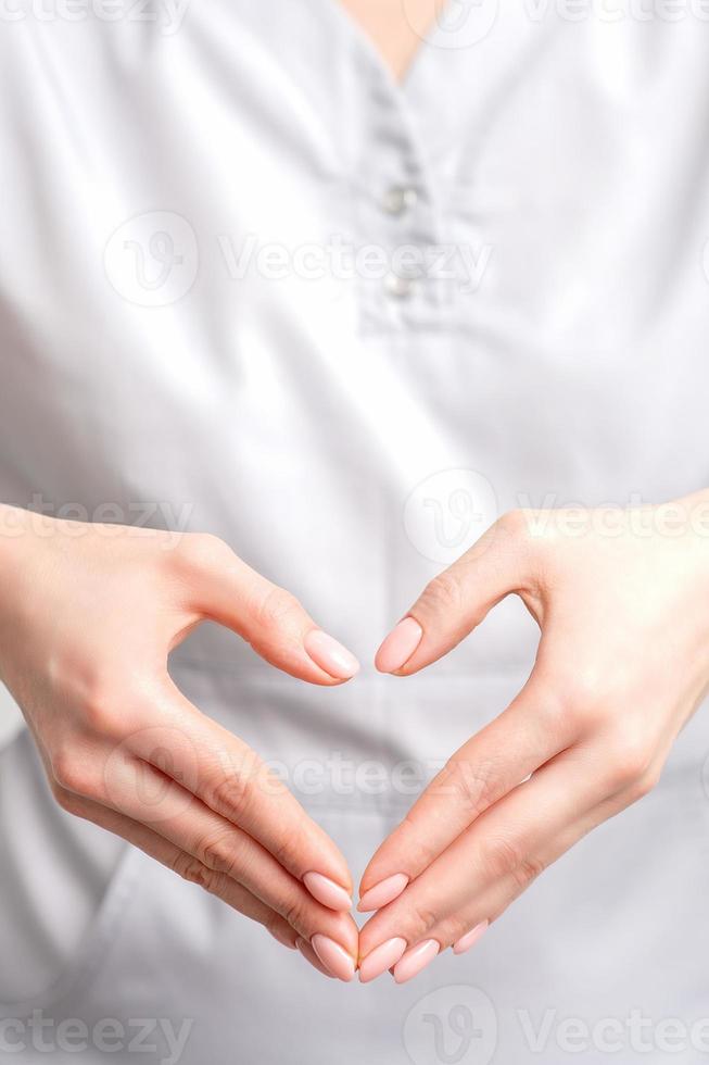 kvinna händer av läkare framställning hjärta form foto