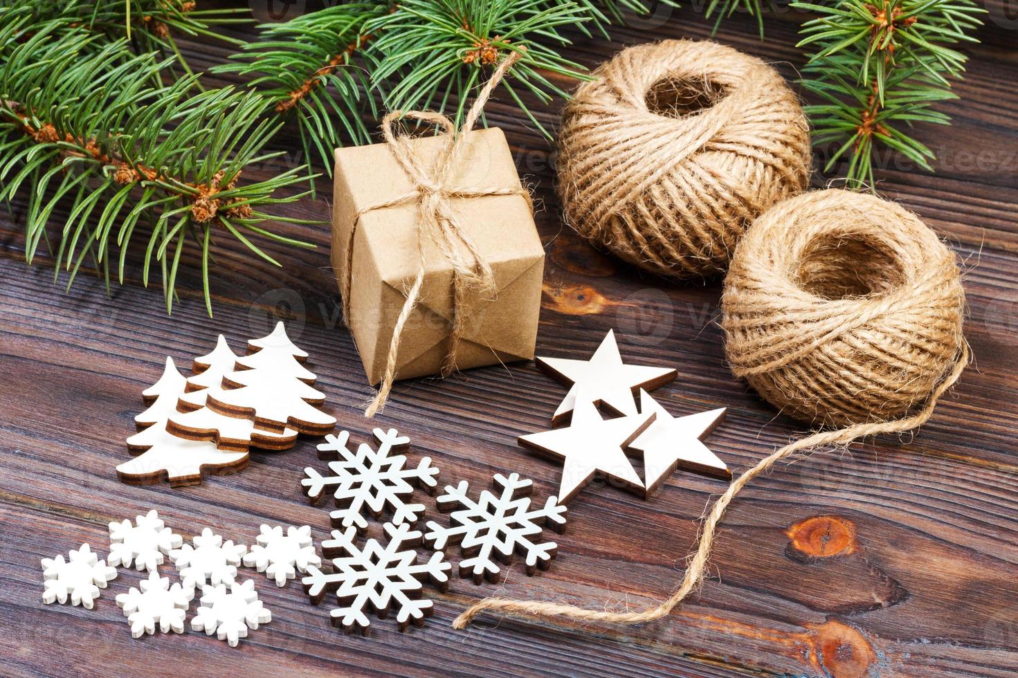 jul dekoration, gåva låda i hantverk papper med snöre rep, begrepp bakgrund, topp se på trä tabell yta. jul ornament och presenterar gräns med snöflingor och stjärnor foto