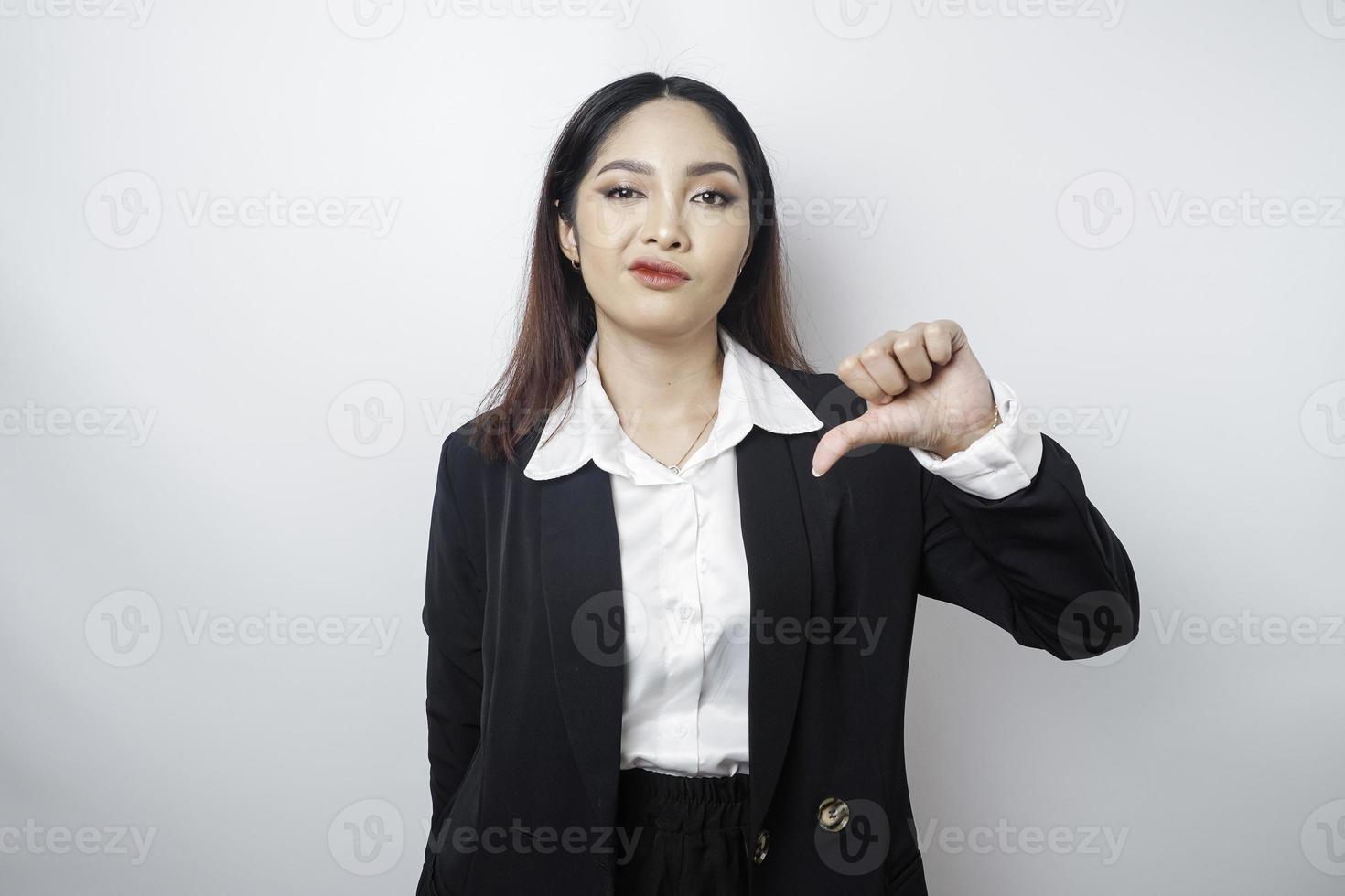 besviken asiatisk affärskvinna ger tummen ner hand gest av ogillande, isolerat förbi en vit bakgrund foto