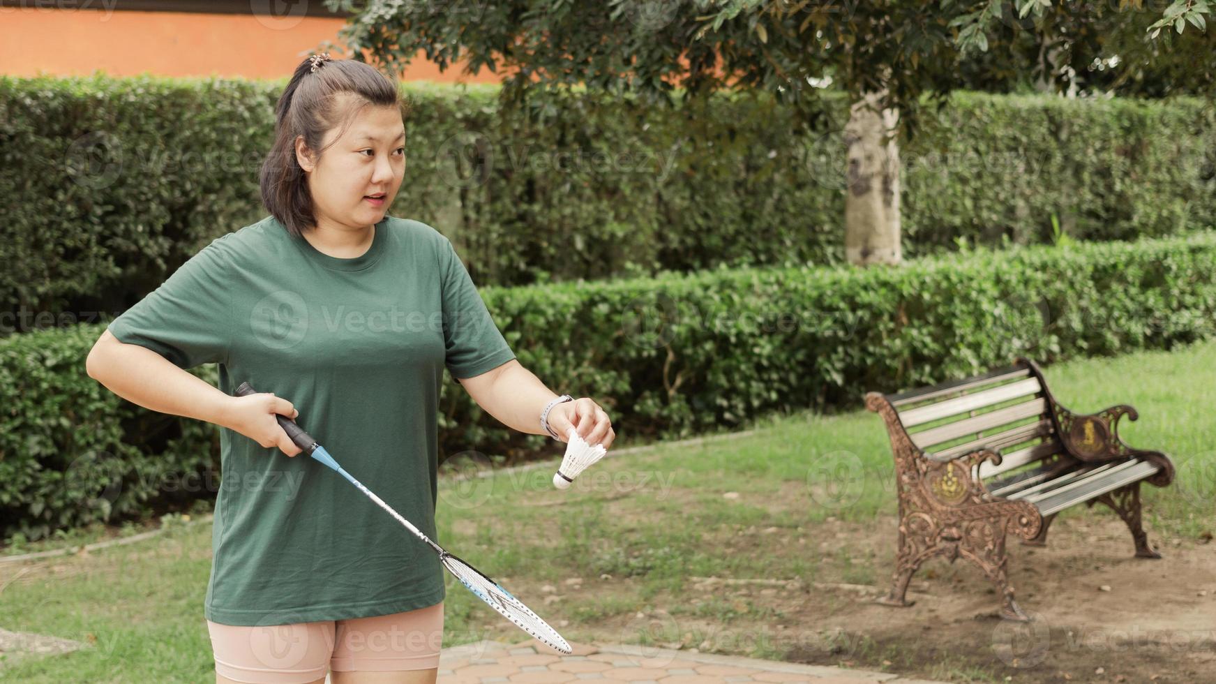 vit grädde badminton badmintonbollar och badminton racketar på hand, suddig träd bakgrund idéer för sporter i en friska i parkera. foto