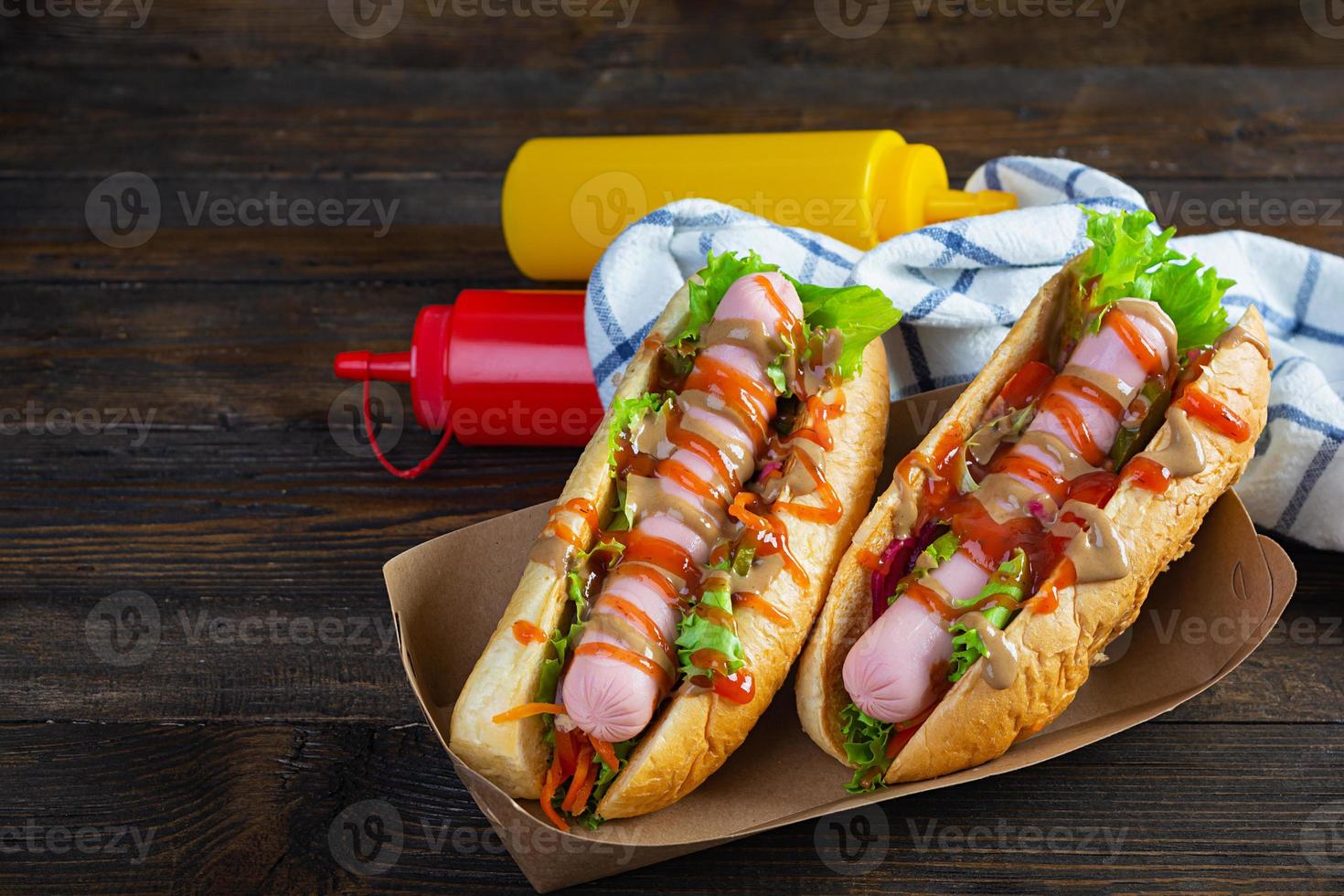 utsökt varm hund med ketchup och senap på trä- bakgrund. gata mat foto