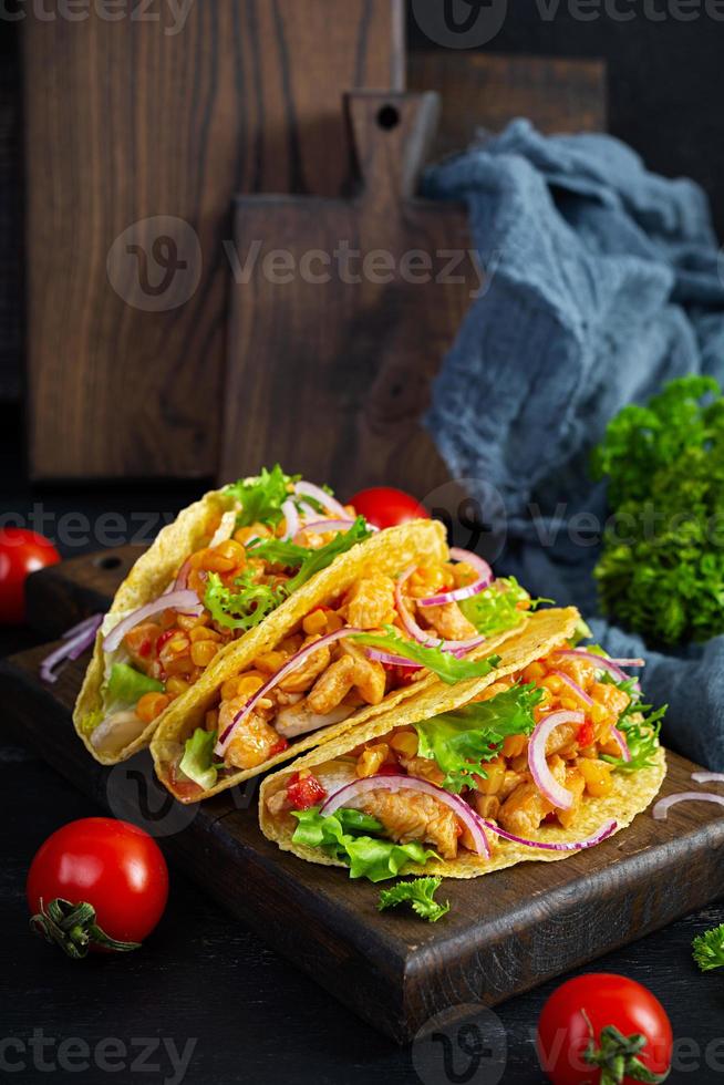 mexikansk tacos med majs tortilla. tortilla med kyckling kött, majs, sallad och lök foto