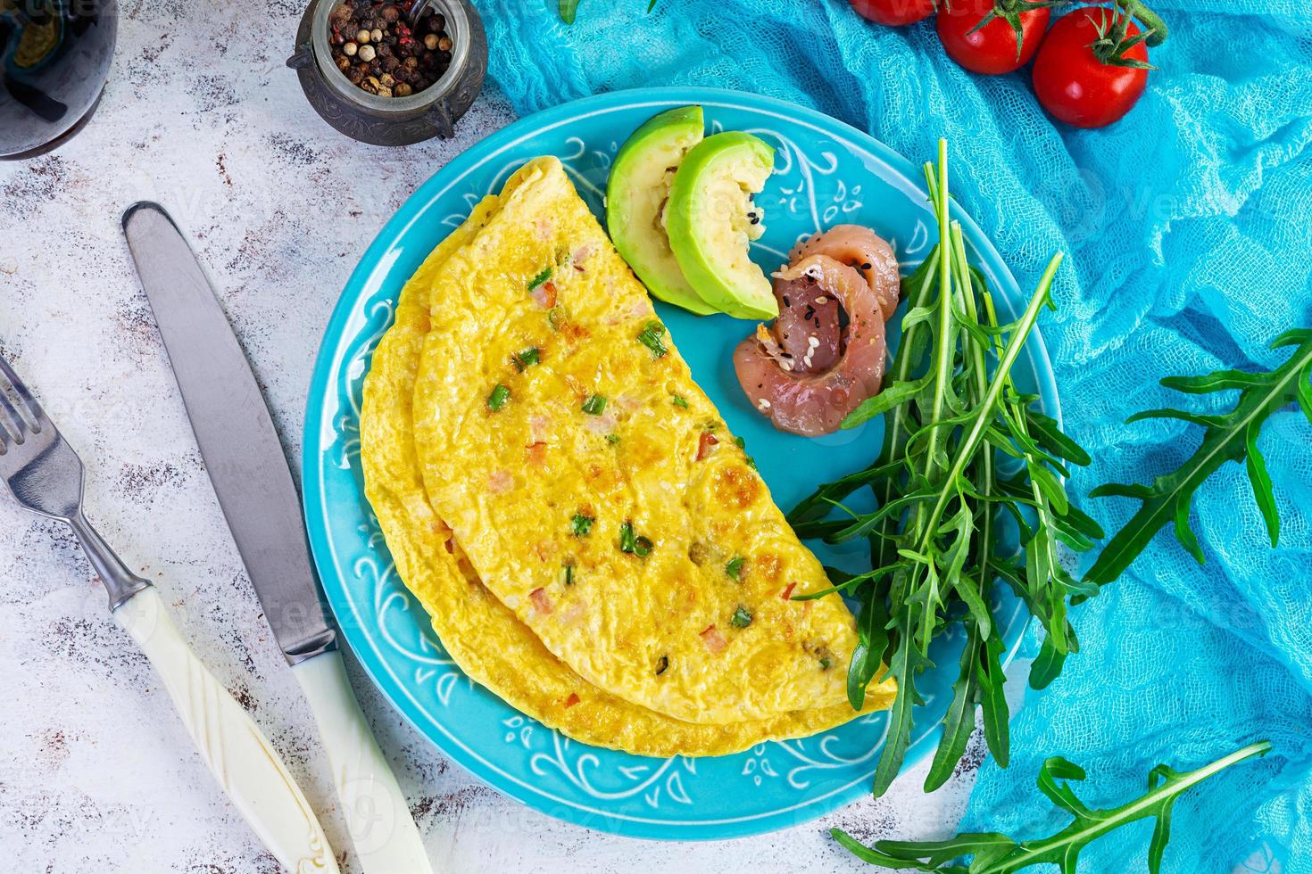 friterad omelett med skinka, lök och örter. frukost med krypterade ägg foto