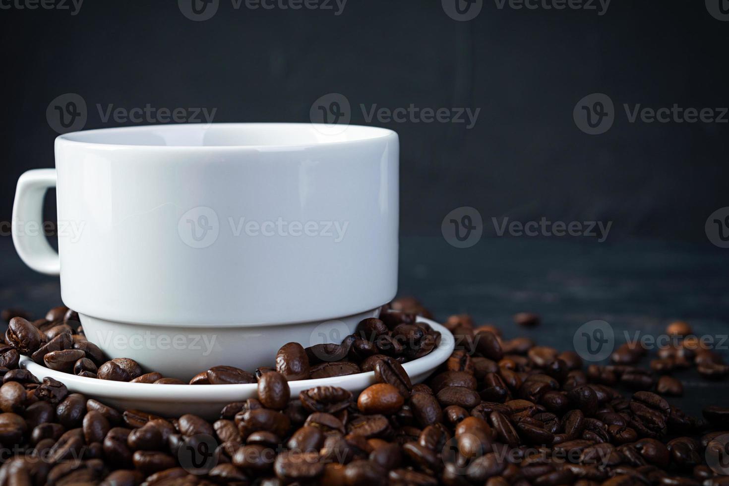 kopp av kaffe med kaffe bönor på mörk bakgrund. råna av varm dryck kaffe foto