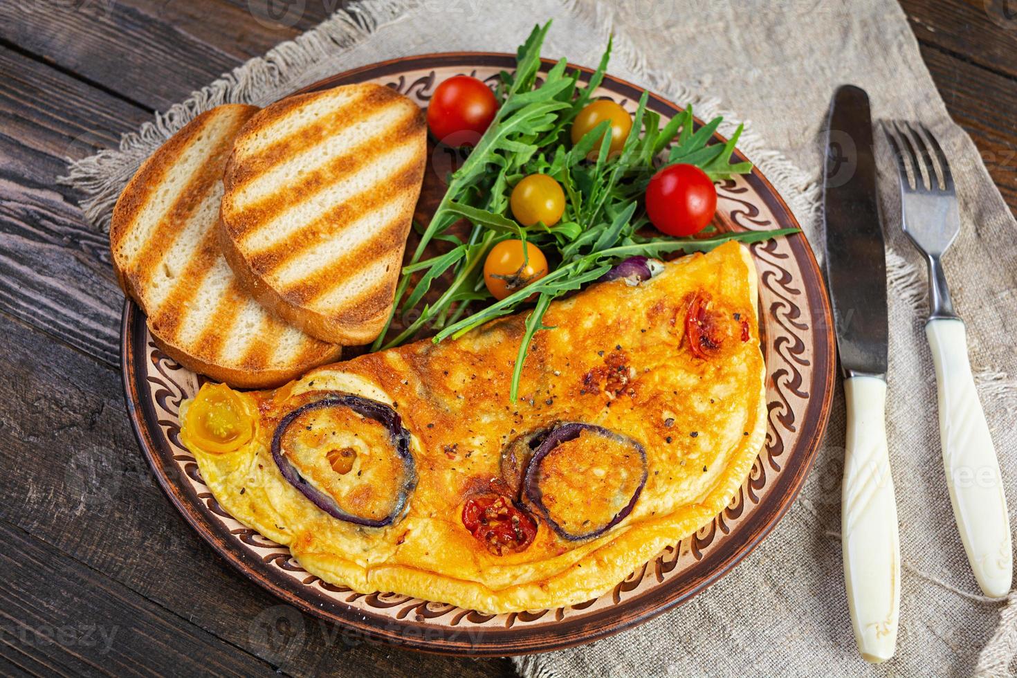 omelett med tomat, lök, ost och örter. gott frukost omelett foto