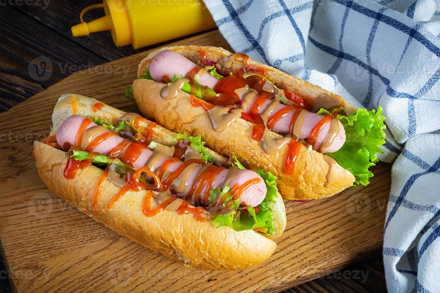 utsökt varm hund med ketchup och senap på trä- bakgrund. gata mat foto