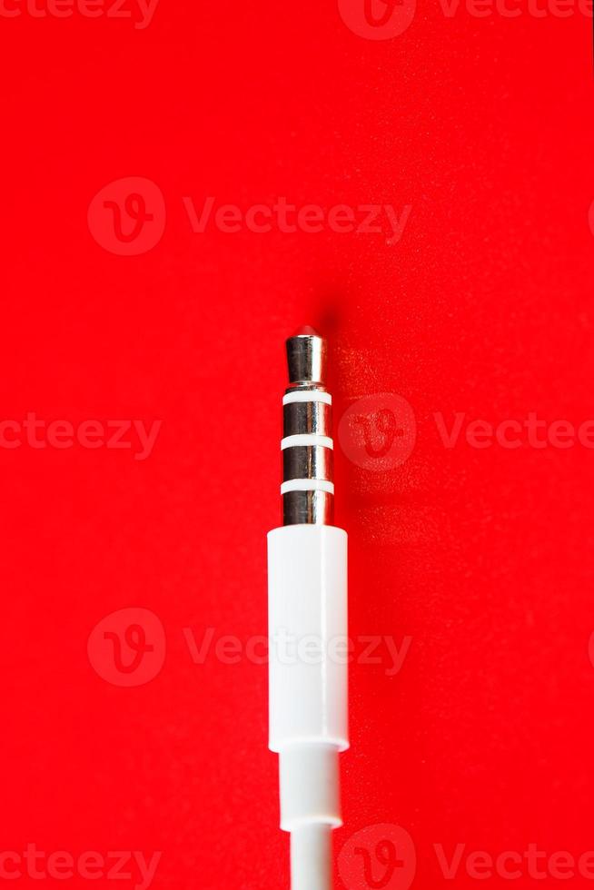 vit kontakt aux vit kabel- på en röd bakgrund foto