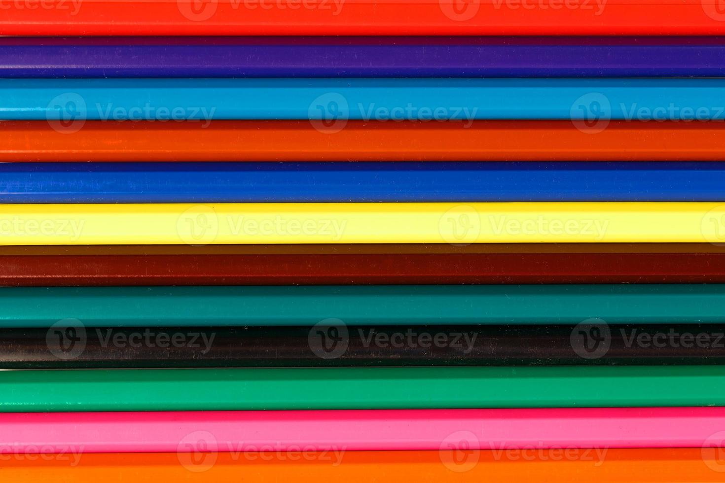 stavar av färgad pennor i en rad som en bakgrund i de hel skärm. foto