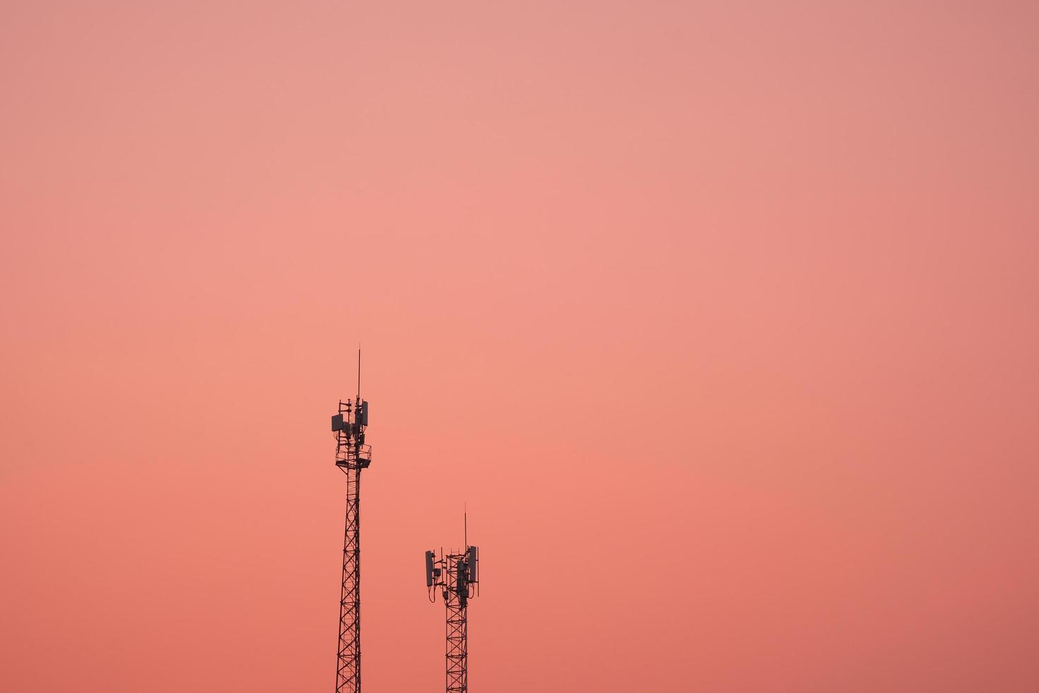 antenn utsända signal telekommunikation i ett rosa orange himmel bakgrund foto