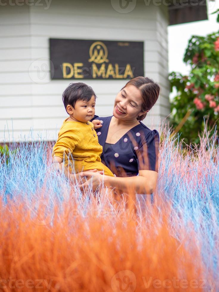 asiatisk mor och son av thai nationalitet och färgrik gräs på de mala Kafé, sväng saliam, sukhothai, thailand. foto