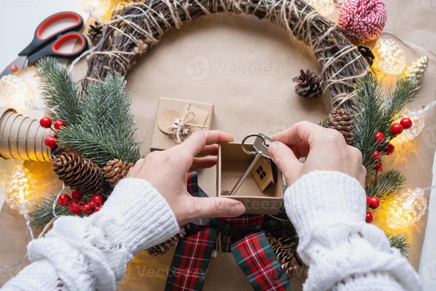 nyckel till hus med Nyckelring på mysigt Hem i gåva låda med jul dekor förpackning. packa närvarande för ny år, jul. byggnad, projekt, rör på sig till ny hus, inteckning, hyra, inköp verklig egendom foto