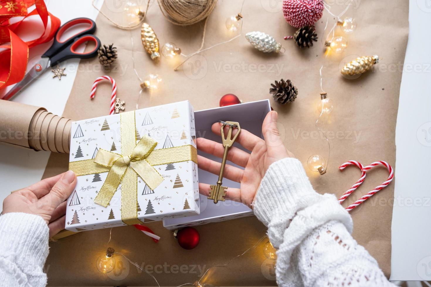 nyckel till hus med Nyckelring på mysigt Hem i gåva låda med jul dekor förpackning. packa närvarande för ny år, jul. byggnad, projekt, rör på sig till ny hus, inteckning, hyra, inköp verklig egendom foto