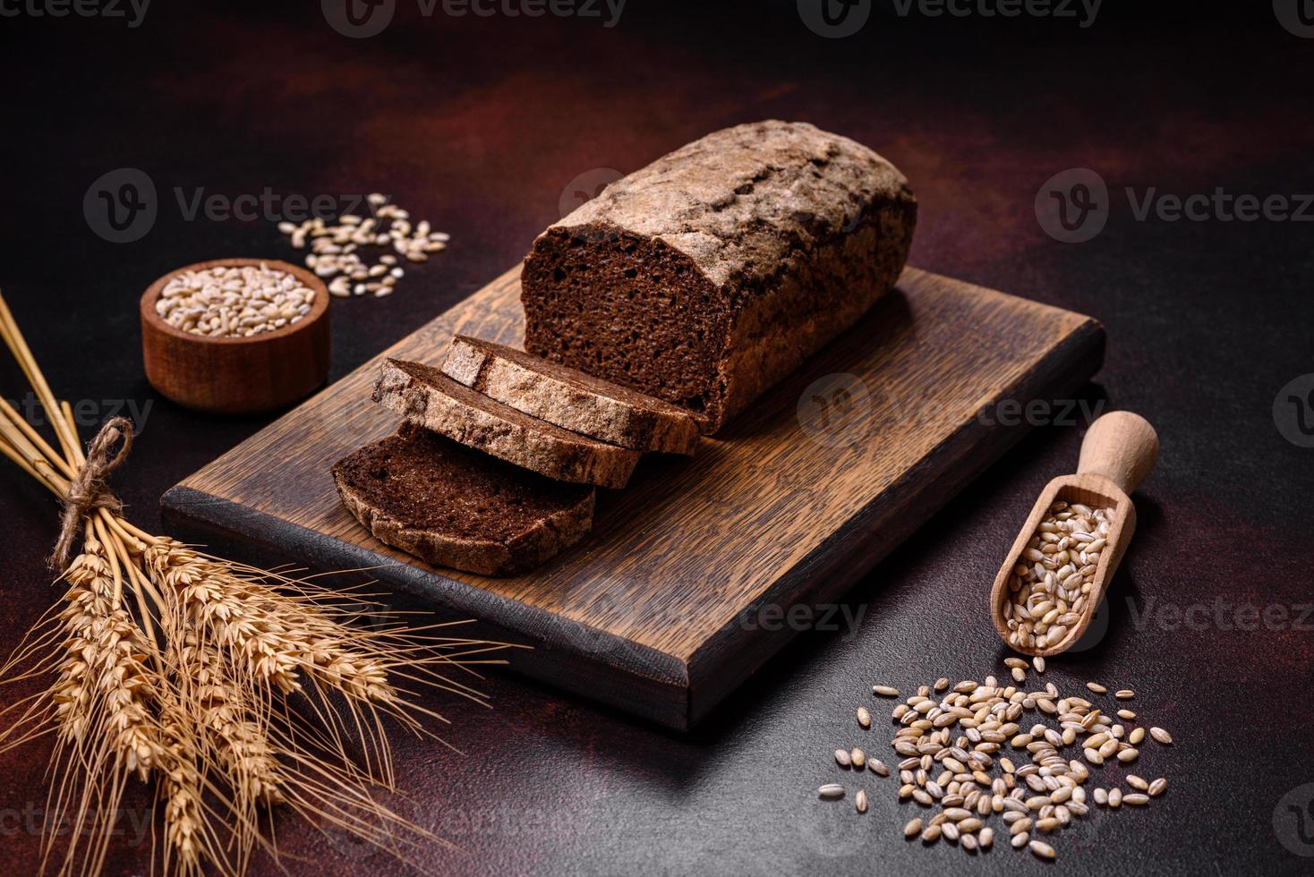 en limpa av brun bröd med korn av spannmål på en trä- skärande styrelse foto