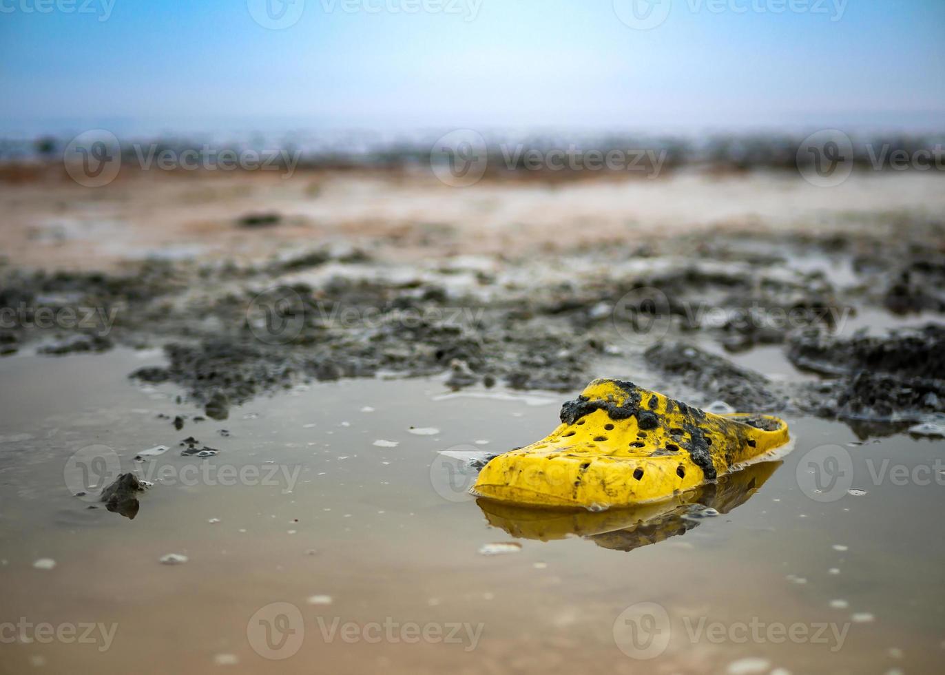 George Hanbury Pelmel Långiver mycket smutsig gul sko på de Strand av en salt sjö på en solig dag.  14675326 Arkivfoto på Vecteezy