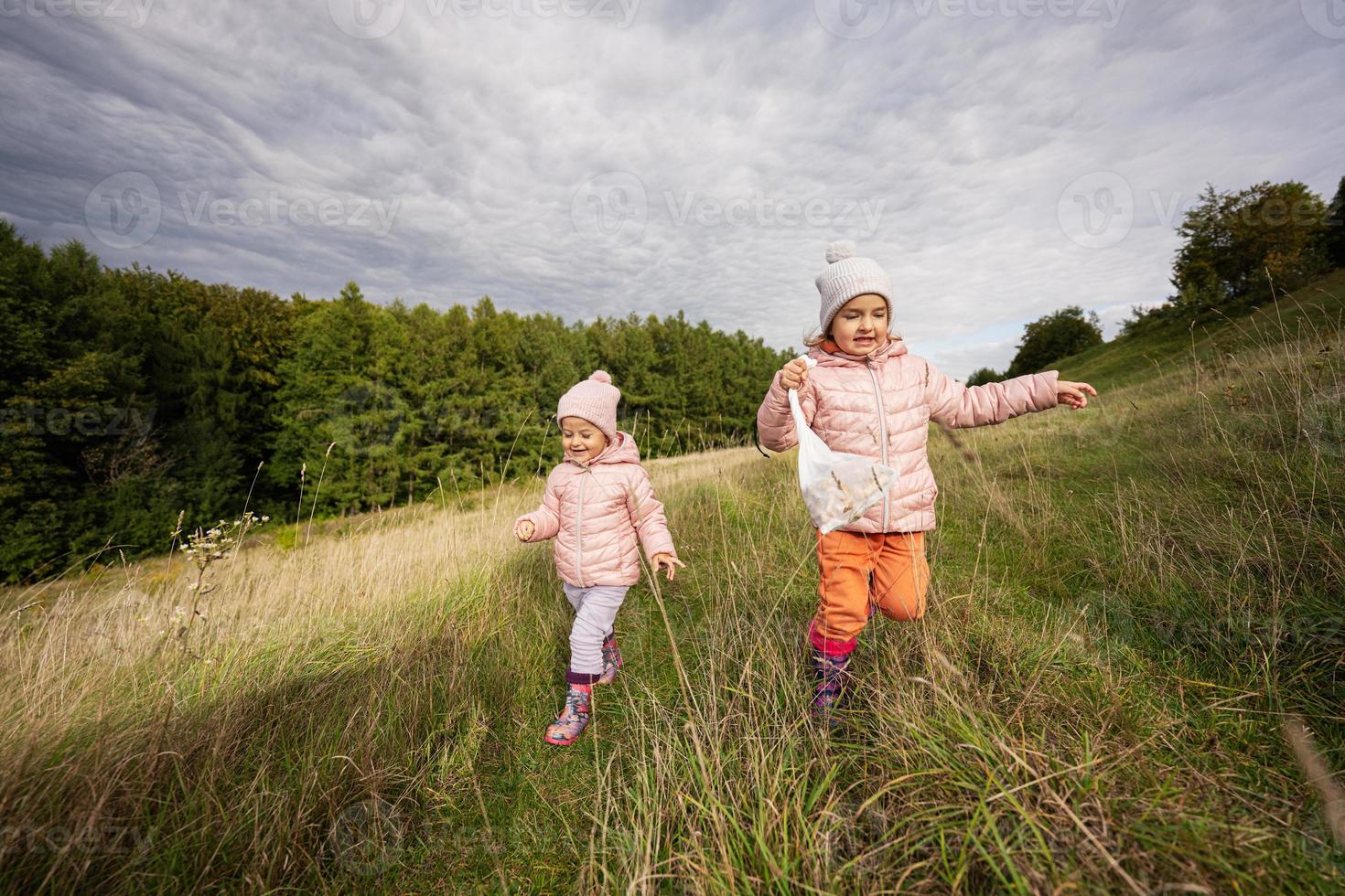 systrar har roligt och springa utomhus- nära skog. foto