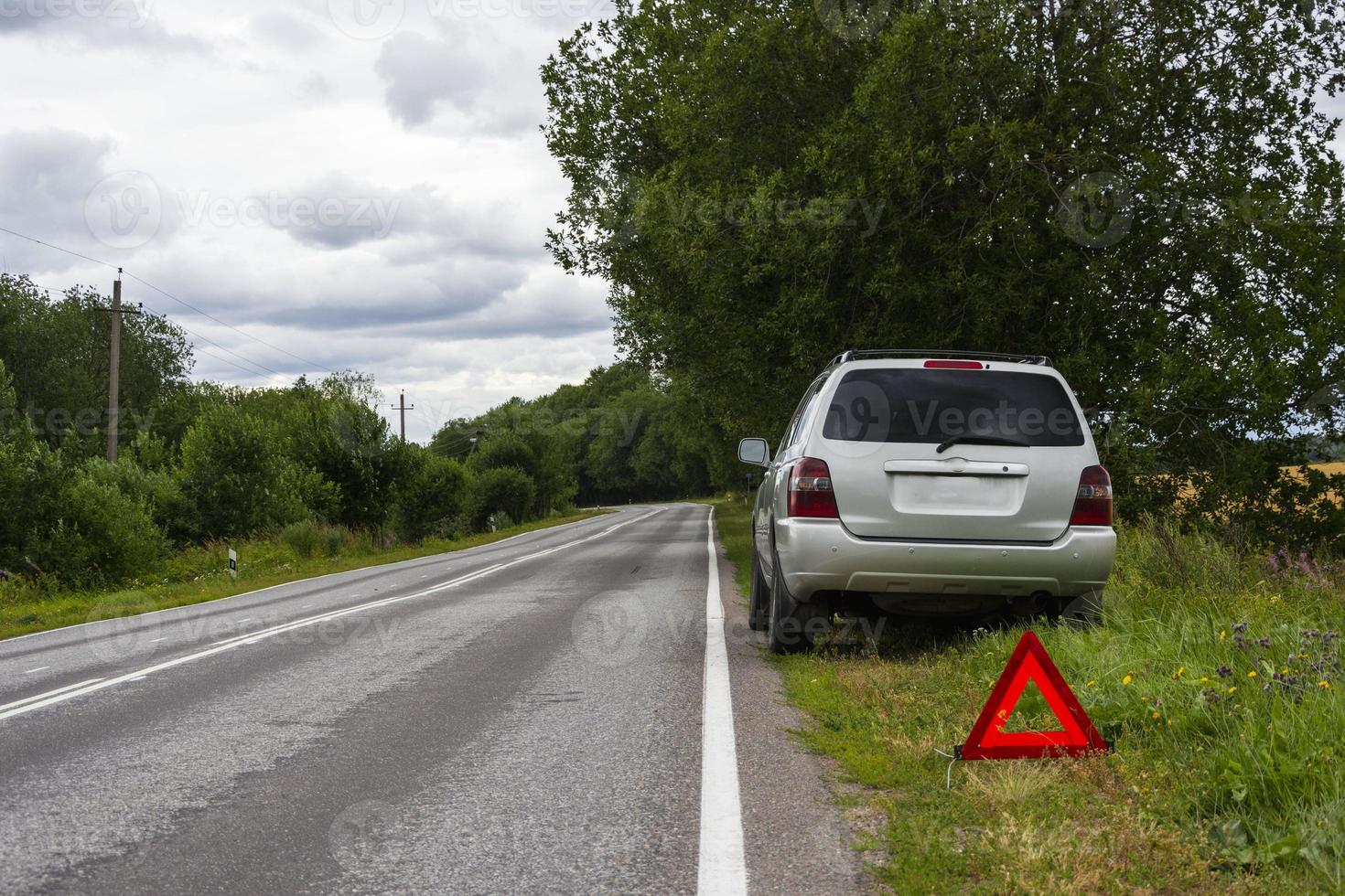 en bil väntar för reparera efter en bryta ner, en bruten bil på de sida av de väg, ett nödsituation sluta tecken foto