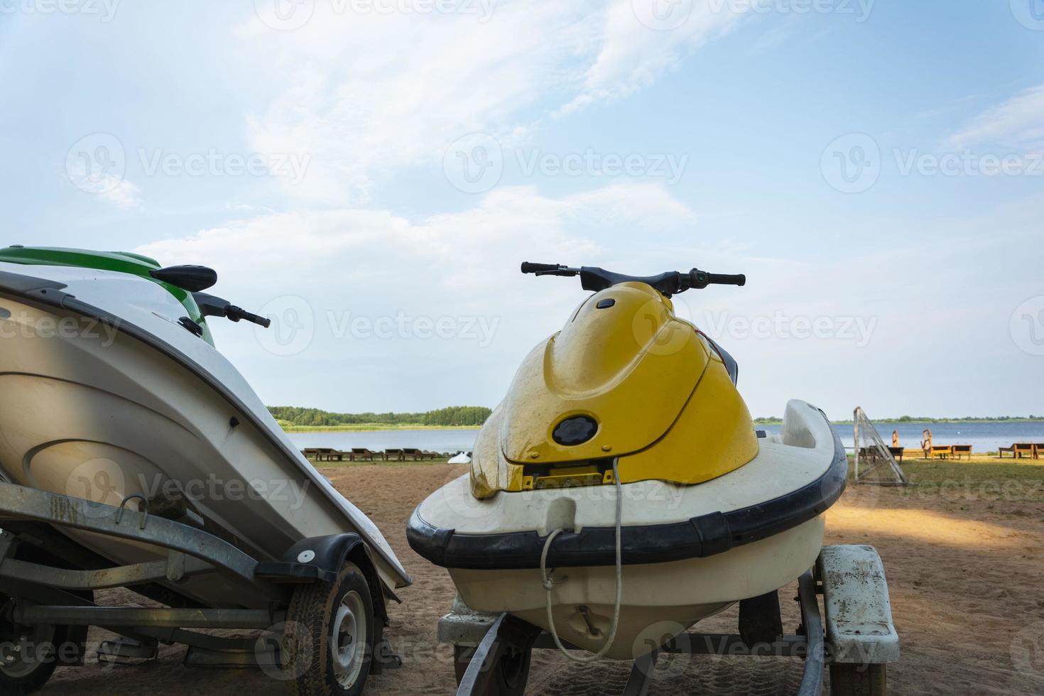 en jet åka skidor parkerad på de strand mot de bakgrund av de sjö och de blå himmel. för de design av ett aktiva livsstil foto