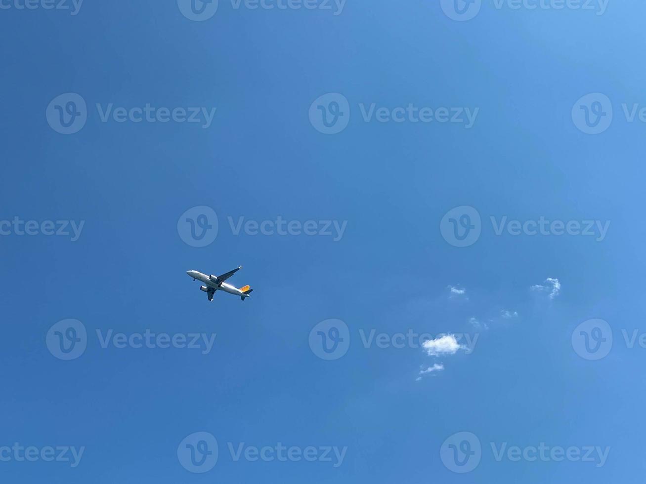 en vit flygplan flygande i en klar blek blå himmel foto