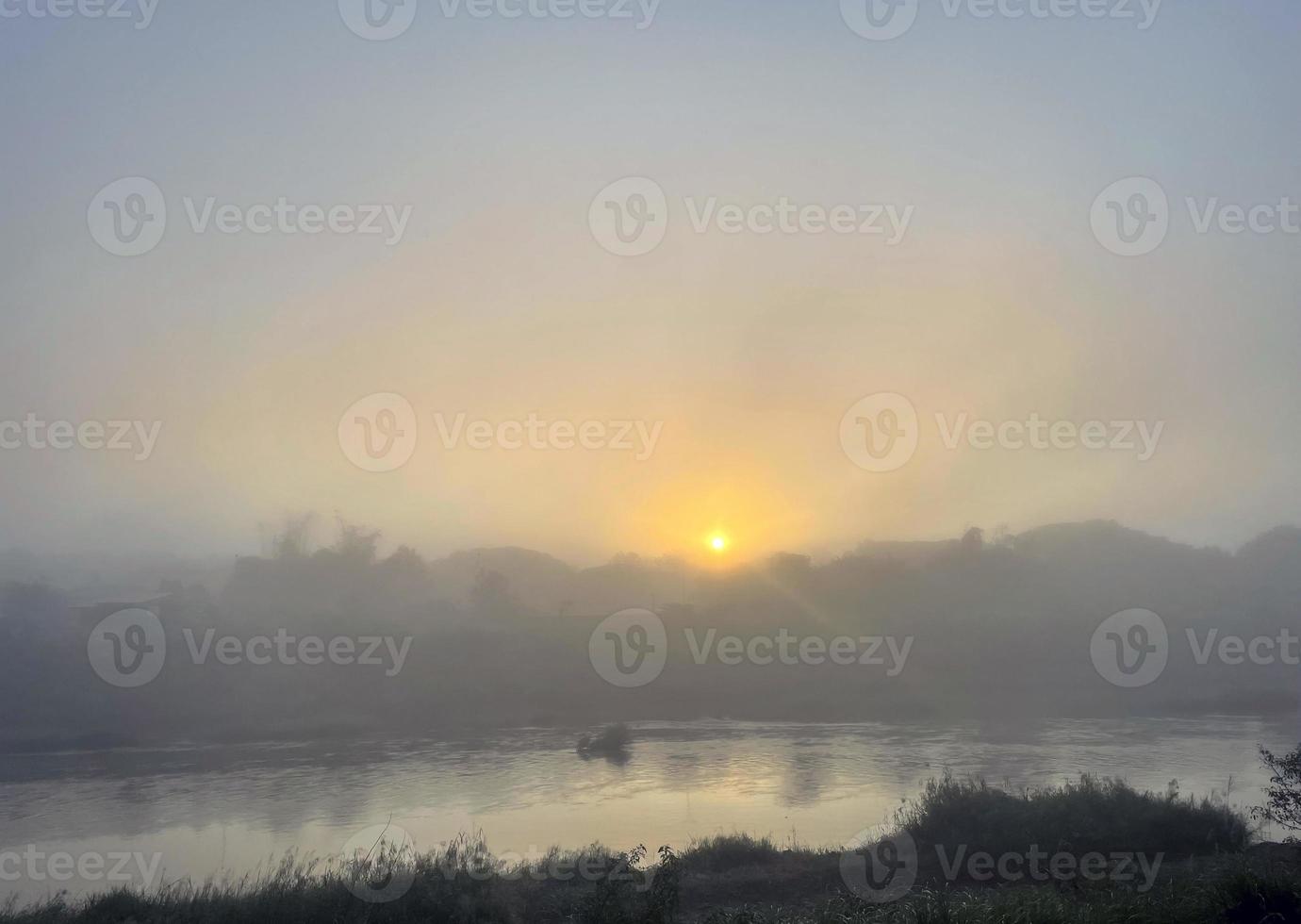 tidigt morgon- flod se de Sol stiger från de horisont i de öster. mjuk gyllene gul solljus träffar de dimma och ånga. mjuk och selektiv fokus foto