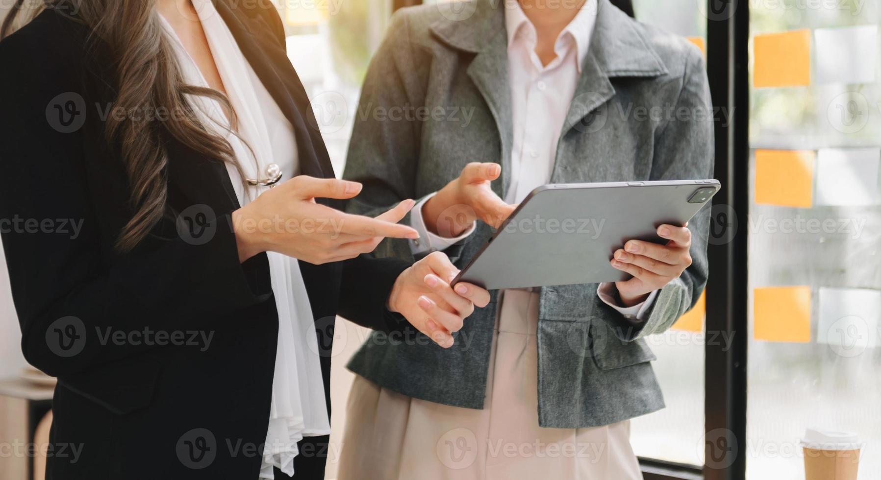 två företag arbetare talande på de smartphone och använder sig av bärbar dator på kontor. foto