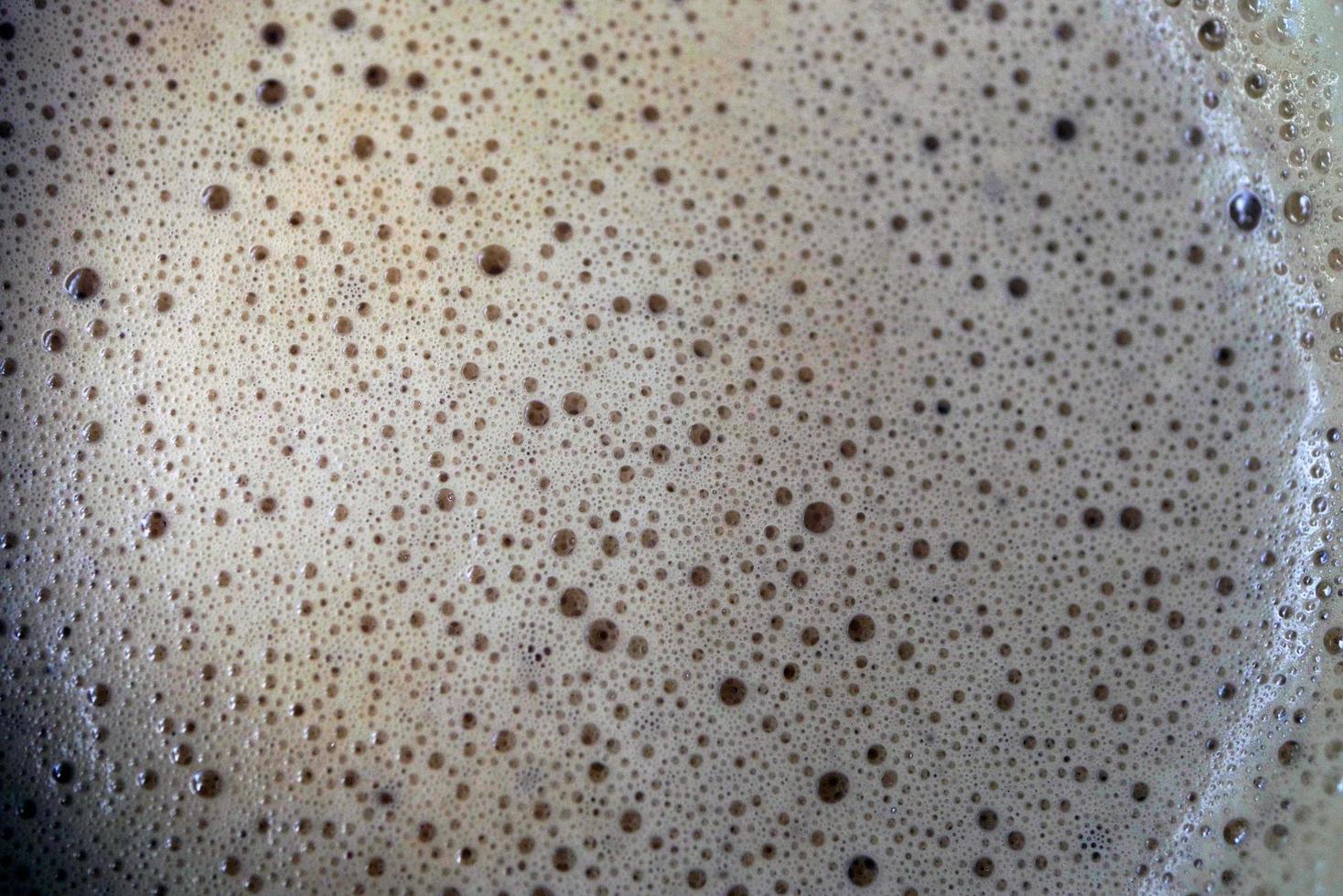 makro fotografi av cappuccino mjölk skum i en glas foto