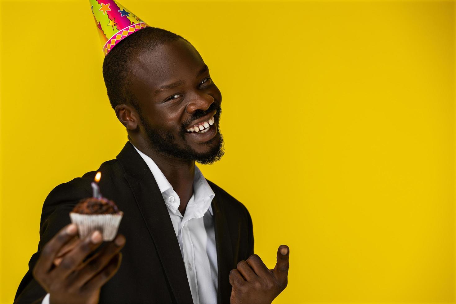 glad söt affärsman som ler mot kameran och håller en födelsedagstårta foto