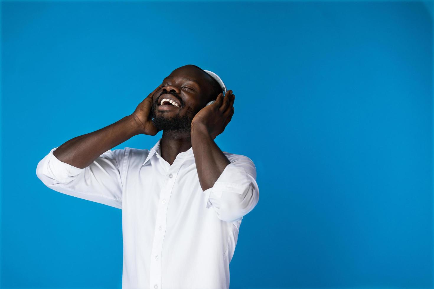 nöjd vacker afroamerikansk kille som lyssnar på musik foto