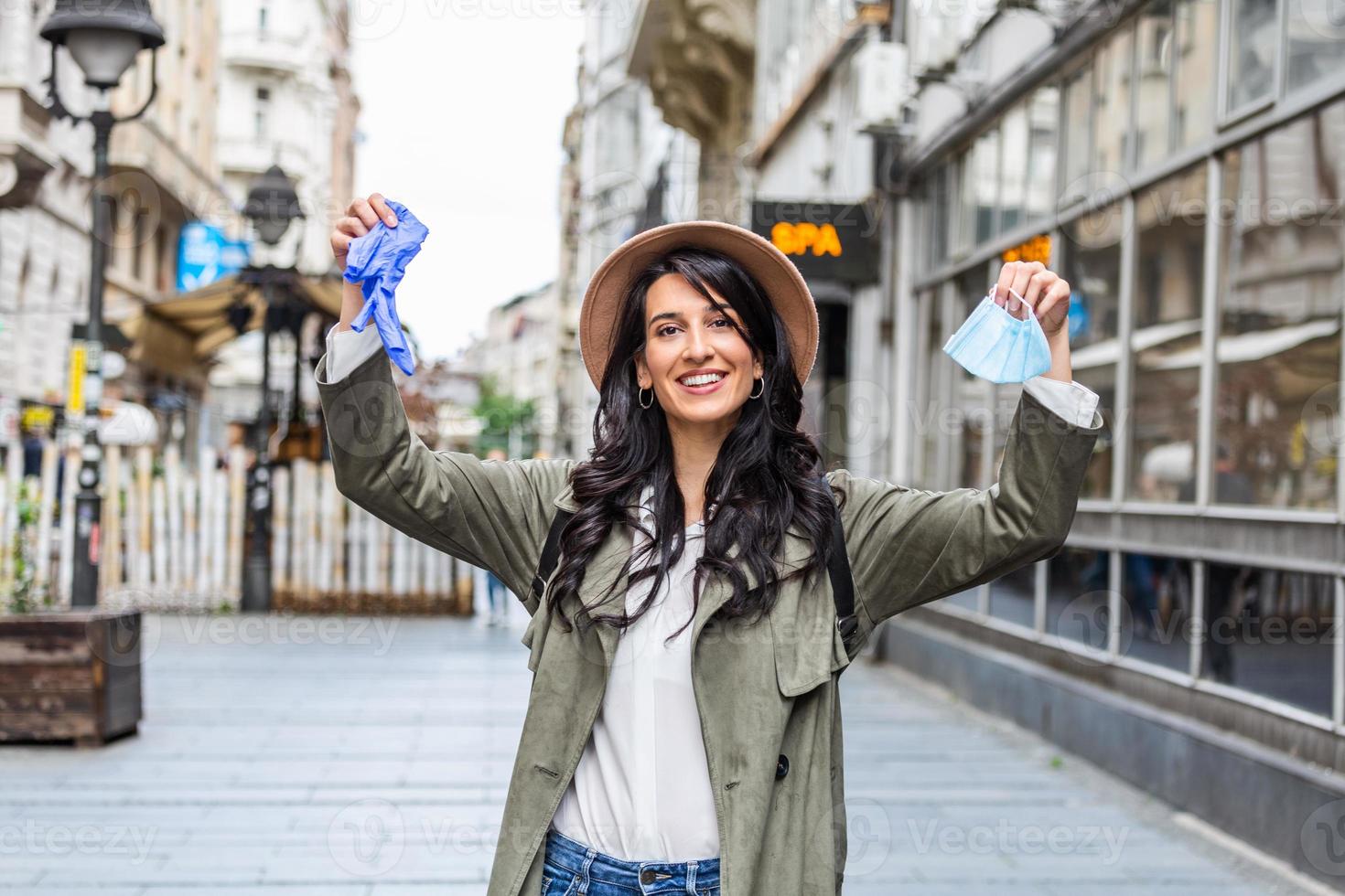 kvinna kasta bort henne mask. Lycklig flicka innehav skyddande medicinsk mask och handskar, ta av ta bort mask från henne ansikte. slutet av pandemi coronavirus begrepp. ncov, covid 19. pollen allergi på vår foto