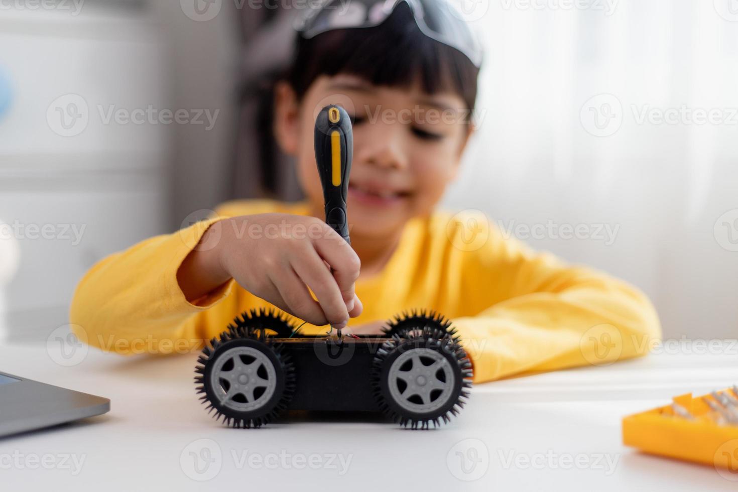 Asien-studenter lär sig hemma i kodning av robotbilar och kablar för elektronikkort i stam, steam, matematik ingenjör vetenskapsteknik datorkod i robotik för barn-koncept. foto