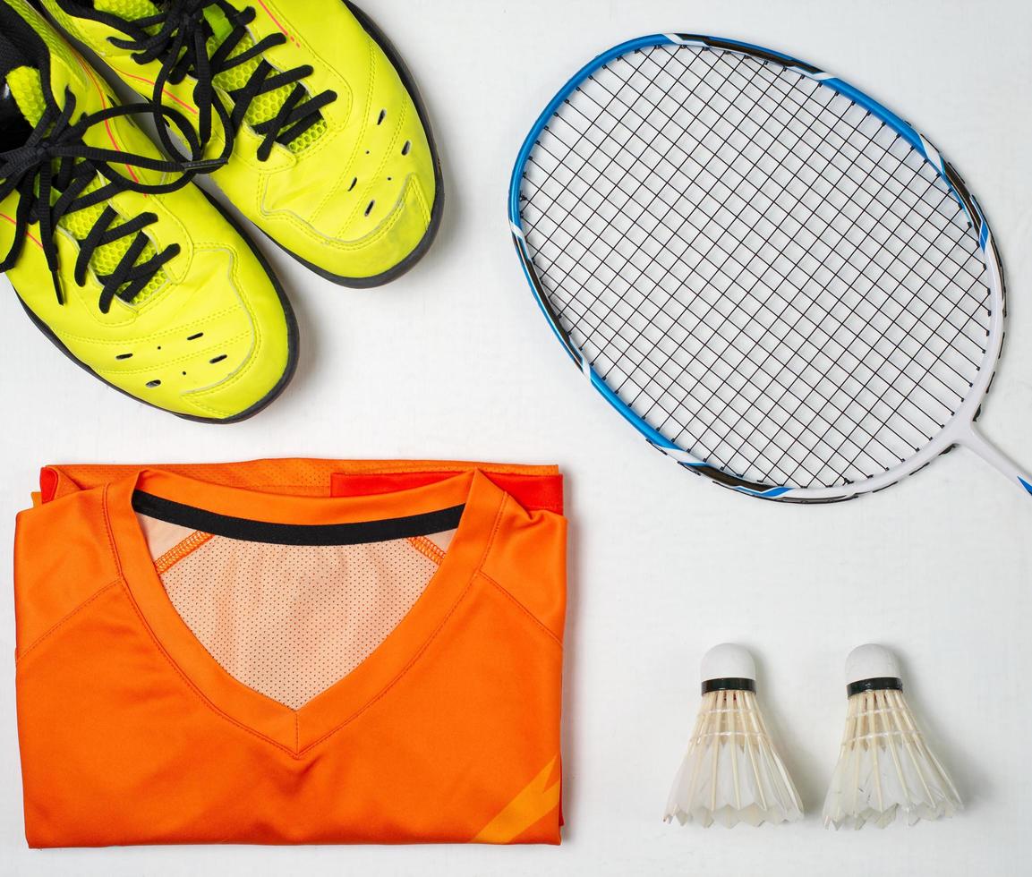 badminton konkurrens Utrustning, badminton racket, badminton boll och skor på vit trä bakgrund foto