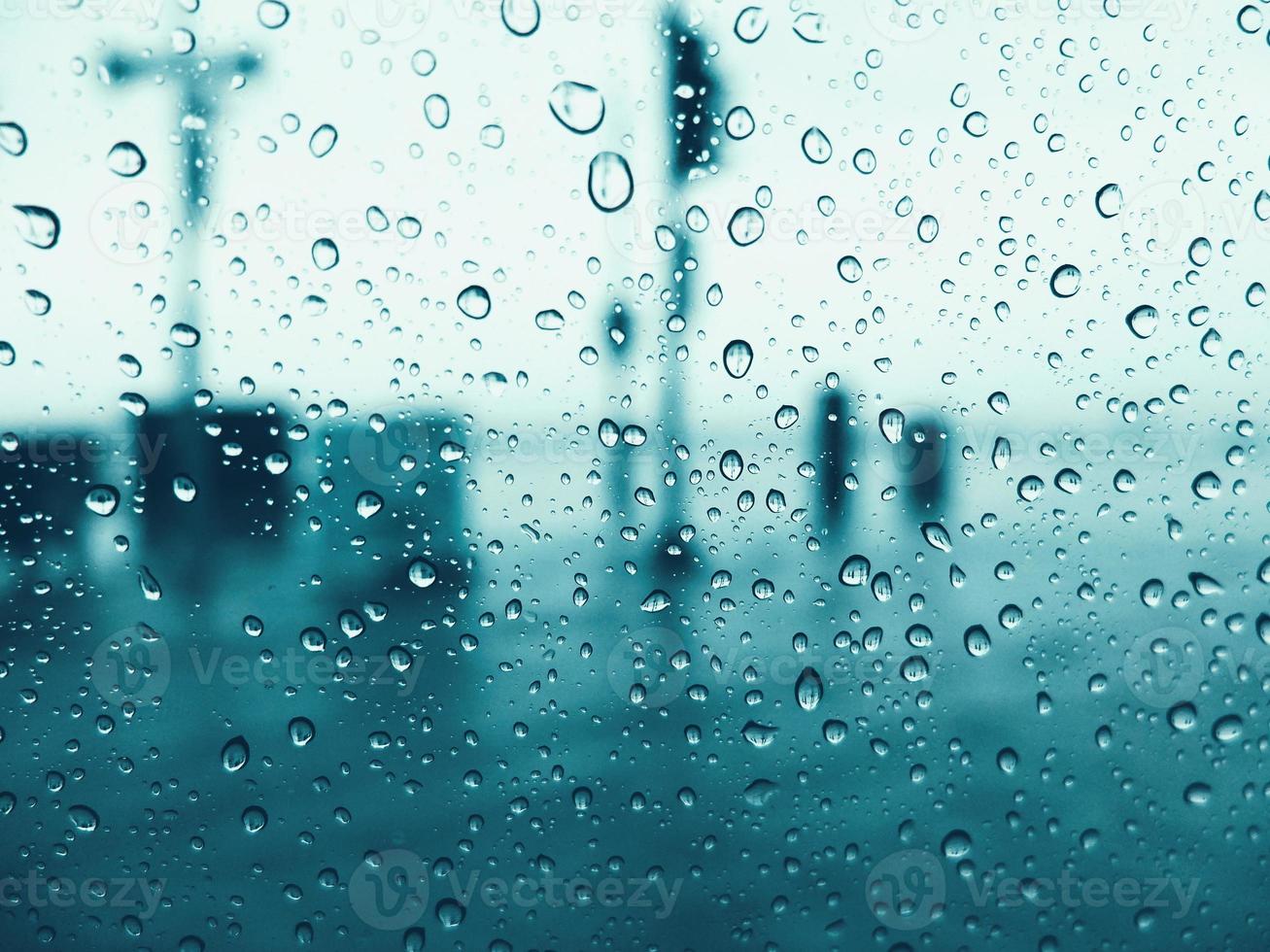 droppar av regn på glas fönster med blå tonad Färg foto